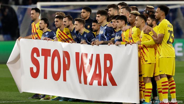 Barcelona and Napoli players hold up a Stop War banner