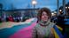 A woman holds Ukrainian flags to demonstrate against Russian attacks in Ukraine. A woman holds Ukrainian flags to demonstrate against Russian attacks in Ukraine.