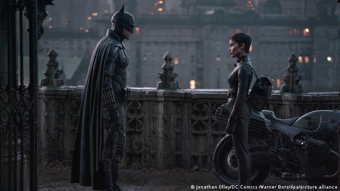 Filmstill The Batman: Robert Pattinson als Batman und Zoe Kravitz als Catwoman schauen sich in einer urbanen Umgebung an.