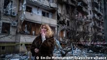 25.02.2022, Ukraine, Kiew: Natali Sewriukowa reagiert neben einem Haus, das bei einem Raketenangriff zerstört wurde. Russische Truppen haben am Donnerstag, 24.02.2022, den erwarteten Angriff auf die Ukraine gestartet. Foto: Emilio Morenatti/AP/dpa +++ dpa-Bildfunk +++