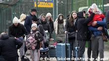 People fleeing the conflict from neighboring Ukraine, arrive at the border crossing in Medyka, southeastern Poland, on Friday, Feb. 25, 2022. Russia pressed its invasion of Ukraine to the outskirts of the capital Friday after unleashing airstrikes on cities and military bases and sending in troops and tanks from three sides in an attack that could rewrite the global post-Cold War security order. (AP Photo/Czarek Sokolowski)