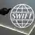 A person holding a phone in front of the SWIFT logo