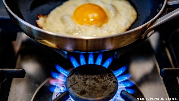 A gas burner on a gas stove is turned on by a resident, to fry an egg in a pan
