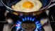 egg being fried on a gas cooker egg being fried on a gas cooker