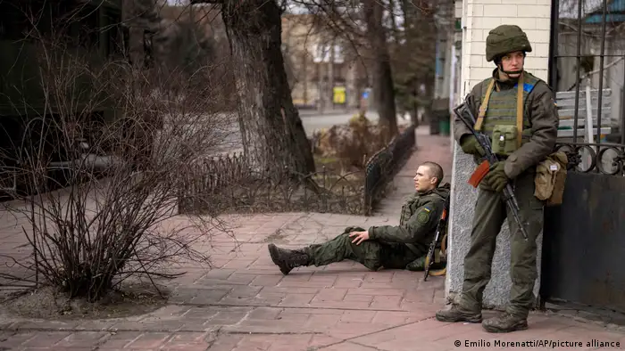 جندي أوكراني جريح وزميله يقف للمراقبة في كييف (25/2/2022)