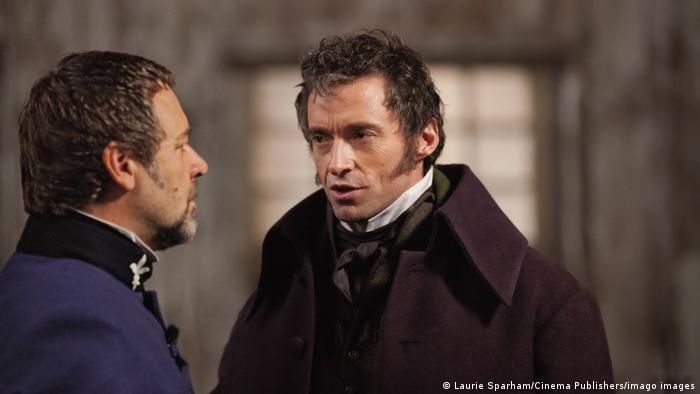 Filmstill aus Les Misérables mit Hugh Jackman als Jean Valjean: zwei Männer stehen sich redend gegenüber
