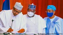 Nigeria Wahlgesetz. Präsident Muhammadu Buhari, Senator Ahmad Lawal und Honorable Femi Gbaja Biamila
Titel: Buhari Wahlgesetz Zeichen
Fotograf/Autor: Nigeria Prasidential Villa
Gesendet von: Ubale Musa, DW Korri in Abuja Nigeria Wann wurde das Bild gemacht? 25.02.2022
Bildbeschreibung: Nigeria Wahlgesetz
