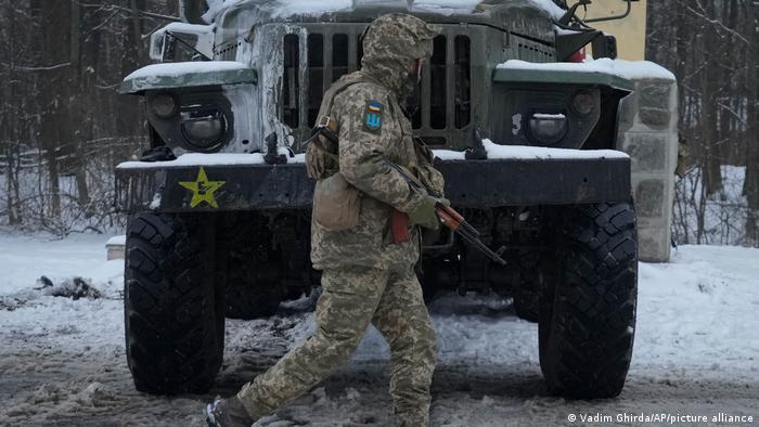 Soldado ucraniano camina delante de un vehículo militar en Kiev.