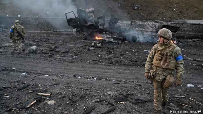 След размяна на въздушни удари украински войници претърсват на 26 февруари 2022 района за неизбухнали гранати. Преди това украинската армия е отблъснала руска атака срещу столицата Киев, гласи уточнението на украинската страна.