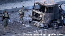 Soldados ucranianos delante de un vehículo militar incendiado por bombardeos rusos en Kiev. (26.02.2022).