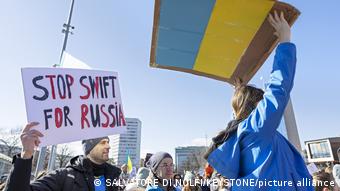 Демонстрация в Женева: Спрете SWIFT за Русия пише на този плакат