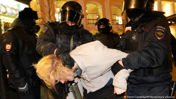 Policemen holding down a protester in Saint Petersburg