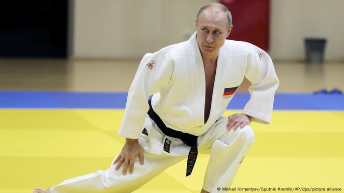 Russian President Vladimir Putin lunging to his left in a judo outfit