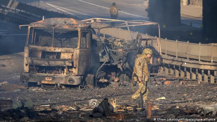 Украински войник оглежда пораженията: този камион е изгорял напълно, от него е останал само скелетът. Не е ясно дали превозното средство е на военните, но е факт, че в Украйна сега биват поразявани не само военни цели.