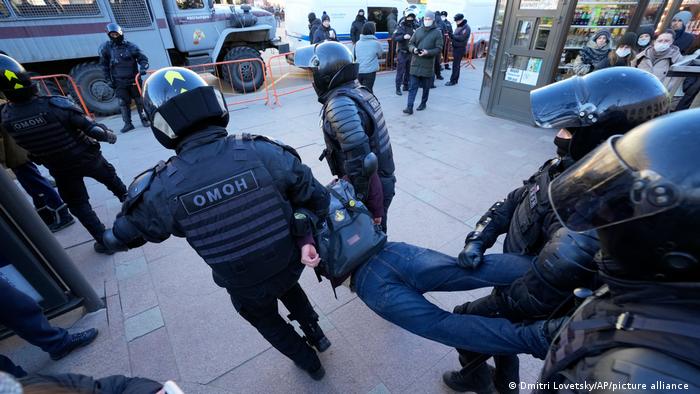 An anti-war protester is carried away by police in St Petersburg