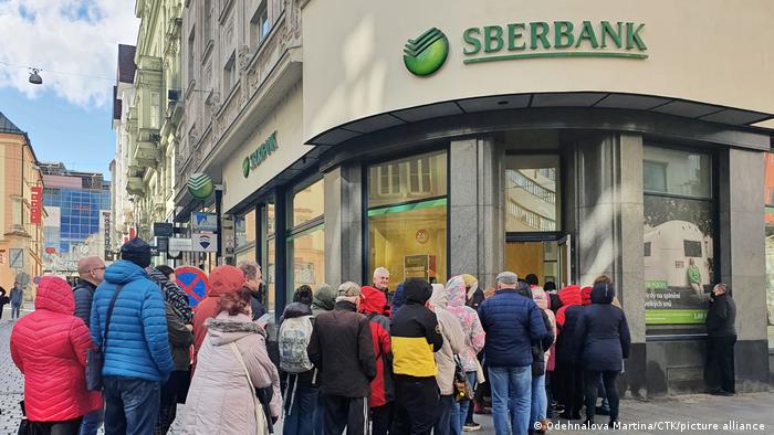 Foto de personas que hacen fila para ingresar a una filial del Sberbank.