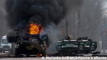 An armored personnel carrier burns and damaged light utility vehicles stand abandoned after fighting in Kharkiv, Ukraine, Sunday, Feb. 27, 2022. The city authorities said that Ukrainian forces engaged in fighting with Russian troops that entered the country's second-largest city on Sunday. (AP Photo/Marienko Andrew)