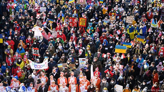 Revellers march with banners for peace and placards in the Ukrainian colors in the center of Cologne, western Germany, on February 28, 2022, where a Freedom for Ukraine demonstration instead of the traditional carnival Rose Monday procession has been organized. 