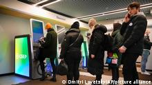 People stand in line to withdraw money from an ATM in Sberbank in St. Petersburg, Russia, Friday, Feb. 25, 2022. Russians flocked to banks and ATMs on Thursday and Friday shortly after Russia launched an attack on Ukraine and the West announced crippling sanctions. According to Russia's Central Bank, on Thursday alone Russians have withdrawn 111 billion rubles (about $1.3 billion) in cash. (AP Photo/Dmitri Lovetsky)