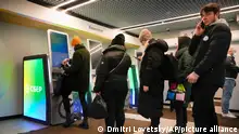 People stand in line to withdraw money from an ATM in Sberbank in St. Petersburg, Russia, Friday, Feb. 25, 2022. Russians flocked to banks and ATMs on Thursday and Friday shortly after Russia launched an attack on Ukraine and the West announced crippling sanctions. According to Russia's Central Bank, on Thursday alone Russians have withdrawn 111 billion rubles (about $1.3 billion) in cash. (AP Photo/Dmitri Lovetsky)