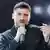 Singer Sergey Lazarev with a microphone looking at the camera