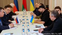 Members of delegations from Ukraine and Russia, including Russian presidential aide Vladimir Medinsky (2L), Ukrainian presidential aide Mykhailo Podolyak (2R), Volodymyr Zelensky's Servant of the People lawmaker Davyd Arakhamia (3R), hold talks in Belarus' Gomel region on February 28, 2022, following the Russian invasion of Ukraine. (Photo by Sergei KHOLODILIN / BELTA / AFP) / Belarus OUT