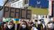 People at a demonstration in Cologne holding a sign saying "Peace." People at a demonstration in Cologne holding a sign saying "Peace."