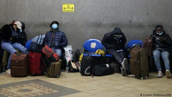 A group of people sitting on their bags
