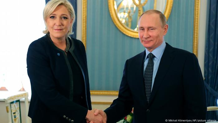 Marine Le Pen shaking hands with Vladimir Putin in 2017 