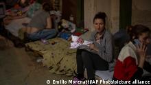 A woman holds her newborn baby at a basement used as a bomb shelter at the Okhmadet children's hospital in central Kyiv, Ukraine, Monday, Feb. 28, 2022. (AP Photo/Emilio Morenatti)