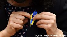A Member of the European Parliament adjusts a pin during a special plenary session of the European Parliament focused on the Russian invasion of Ukraine at the EU headquarters in Brussels, on March 01, 2022. - The European Commission has opened the door for Ukraine to join the EU, but this is not for tomorrow, despite Kiev's request for a special procedure to integrate the country without delay. (Photo by JOHN THYS / AFP) (Photo by JOHN THYS/AFP via Getty Images)
