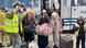 Women and children arrive with suitcases and speak with volunteers, next to a bus Women and children arrive with suitcases and speak with volunteers, next to a bus