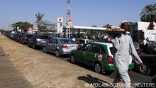 A man selling kola nut walks past vehicles stuck in a traffic in front of the Oando petrol station in Abuja, Nigeria February 11, 2022. REUTERS/Afolabi Sotunde