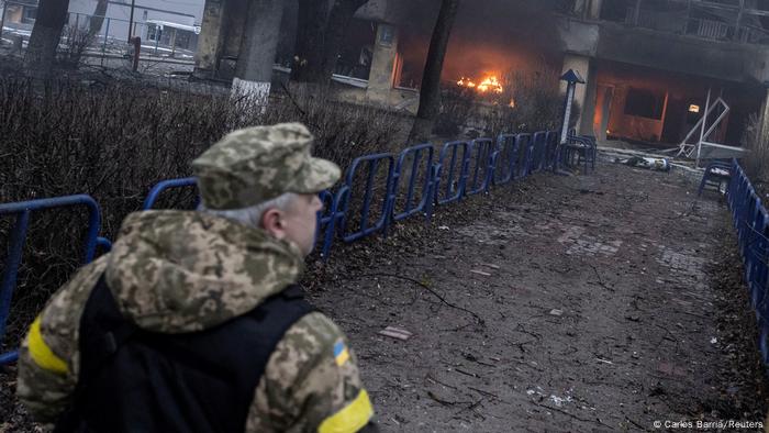 A member of the military walks near a building after a blast, amid Russia's invasion of Ukraine, in Kyiv, Ukraine March 1, 2022.