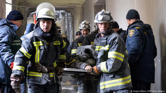 Emergency personnel carry a body out of the damaged local city hall of Kharkiv on March 1, 2022, destroyed as a result of Russian troop shelling. The central square of Ukraine's second city, Kharkiv, was shelled by advancing Russian forces who hit the building of the local administration, regional governor Oleg Sinegubov said.