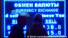 Women look at a screen displaying exchange rate at a currency exchange office in St. Petersburg, Russia, Tuesday, March 1, 2022. The Russian currency plunged about 30% against the U.S. dollar Monday after Western nations announced moves to block some Russian banks from the SWIFT international payment system and to restrict Russia's use of its massive foreign currency reserves. (AP Photo/Dmitri Lovetsky)