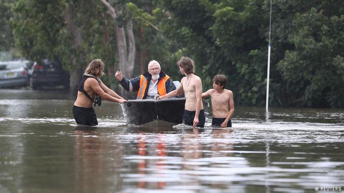 In Chinderah, young people transport an elderly man in a boat