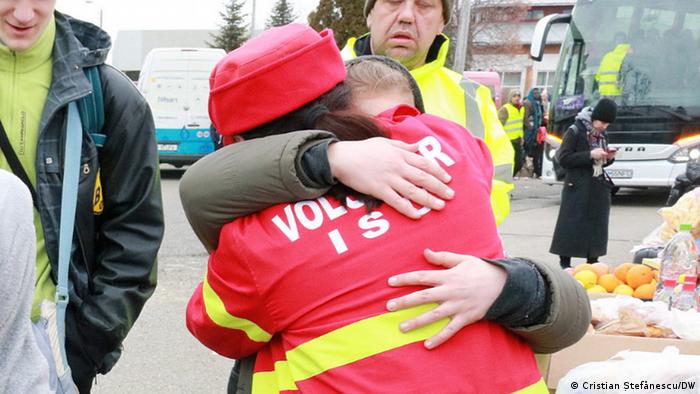 O voluntară îmbrățișează o fetiță din ucraina la Siret 