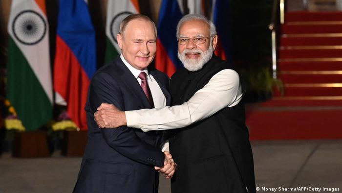 Vladimir Putin and Narendra Modi shake hands in 2021