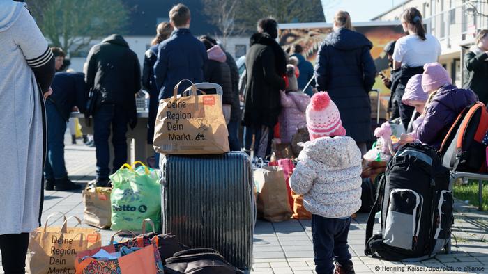 Ukrainians with their belongings wait in front of a refugee facility in Cologne, Germany 