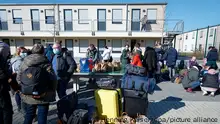 03.03.2022, Geflüchtete aus der Ukraine stehen mit ihrem Gepäck vor den Gebäuden eines Flüchtlingsheims in Köln Worringen.