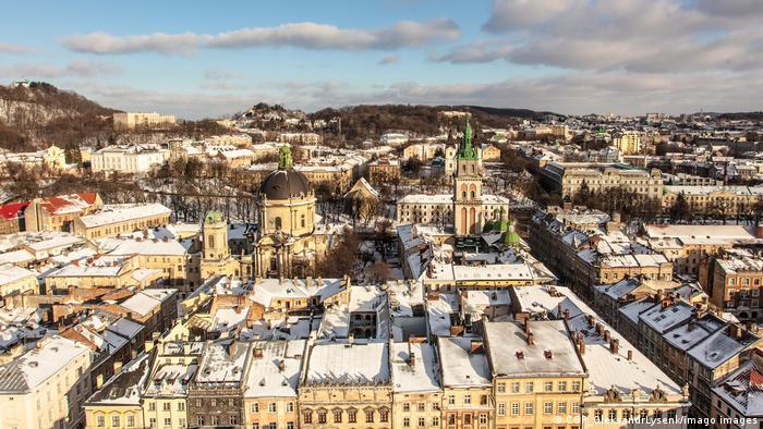 A bird's eye view of the historic center of Lviv in the winter, with the buildings roofs covered in snow