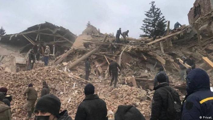Menschen suchen in den Trümmern von Häusern in Okhtyrka in der Ukraine 