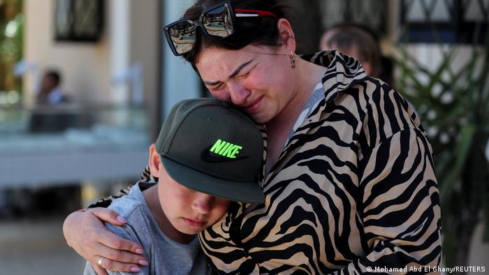 Ukrainian tourist, Ivanna, holds her son Vova while crying at the Egyptian Red Sea tourist resort as they react to the situation in their home country