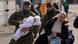 Woman with soliders carrying a baby Woman with soliders carrying a baby