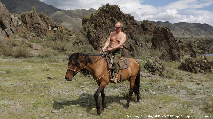 Vladimir Putin shihet duke hipur në një kalë pa këmishë, me male në sfond.
