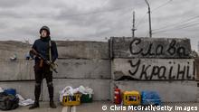KYIV, UKRAINE - MARCH 05: A member of a Territorial Defence unit guards a barricade next to writing saying Glory To Ukraine close to the eastern frontline on March 05, 2022 in Kyiv, Ukraine. Russia continues assault on Ukraine's major cities, including the capital Kyiv, more than a week after launching a large-scale invasion of the country. (Photo by Chris McGrath/Getty Images)