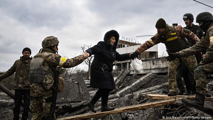 Украинските войници помагат и на тази възрастна жена да напусне Ирпин. Тя не е взела никакъв багаж. Носи само своите спомени. 