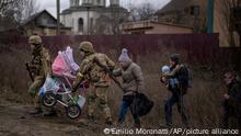 Ukrainian soldiers help a fleeing family crossing the Irpin river in the outskirts of Kyiv, Ukraine, Saturday, March 5, 2022. (AP Photo/Emilio Morenatti)