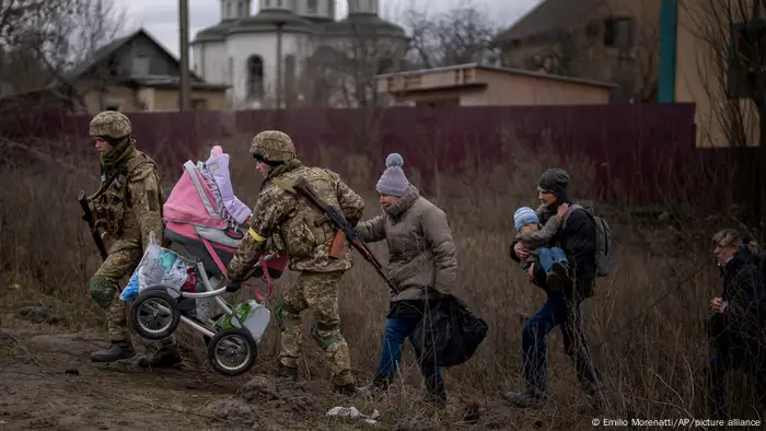 Ukraine, Kiew | Soldaten helfen einer Familie bei der Flucht